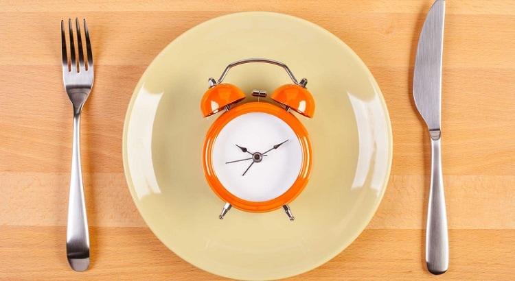 um relógio dentro de um prato vazio, simbolizando o jejum intermitente 